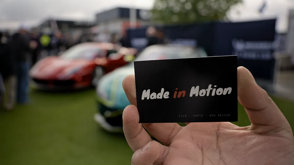 Our card held up in front of the cars at Silverstone