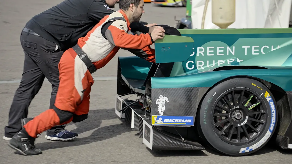 Two mechanics pushing a prototype at Silverstone