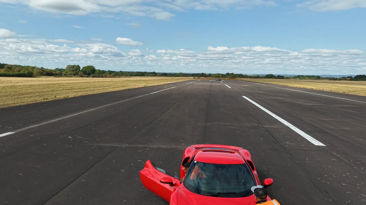 A red Ferrari on the runway, from above