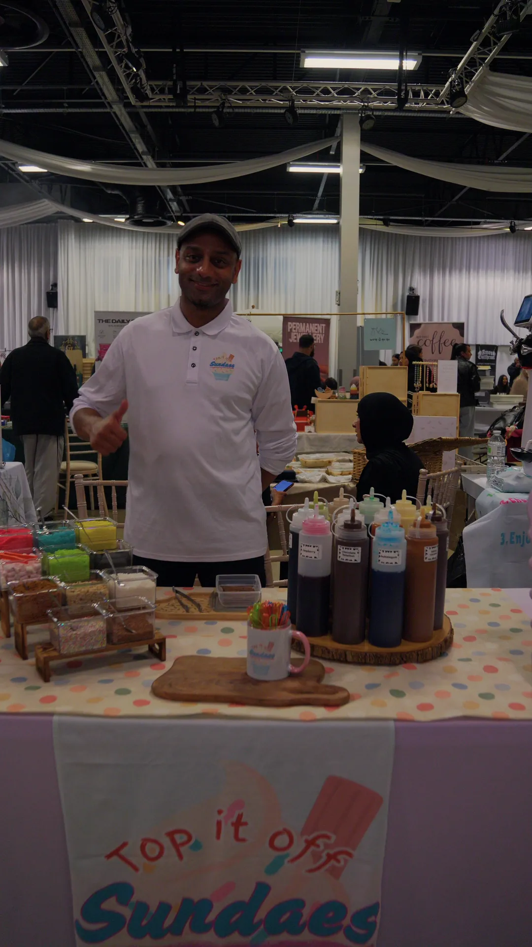 A dessert stall owner behind his sauces at a family fun day