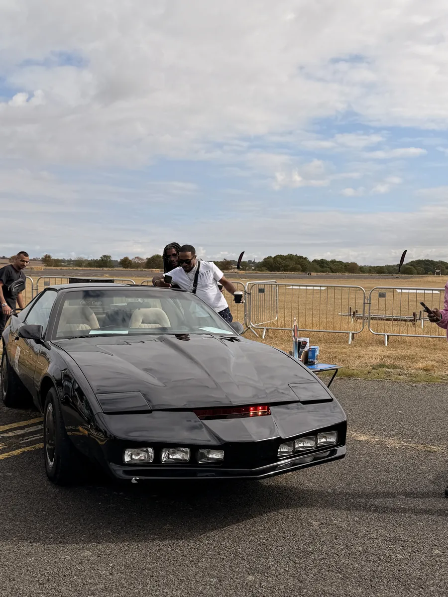 A black eighties TV car at a motor show