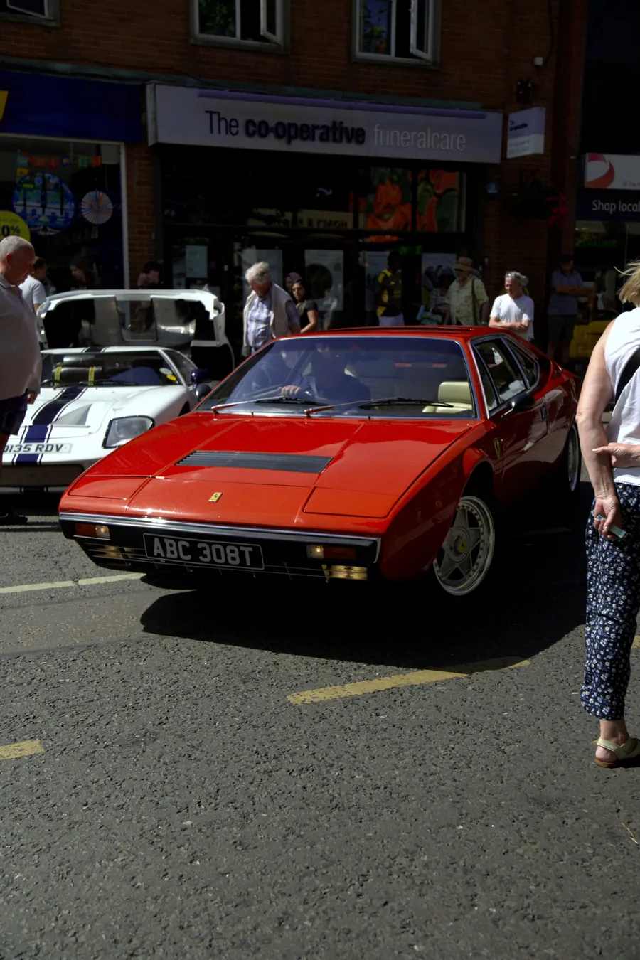 A red Ferrari parked on the high street among the crowd