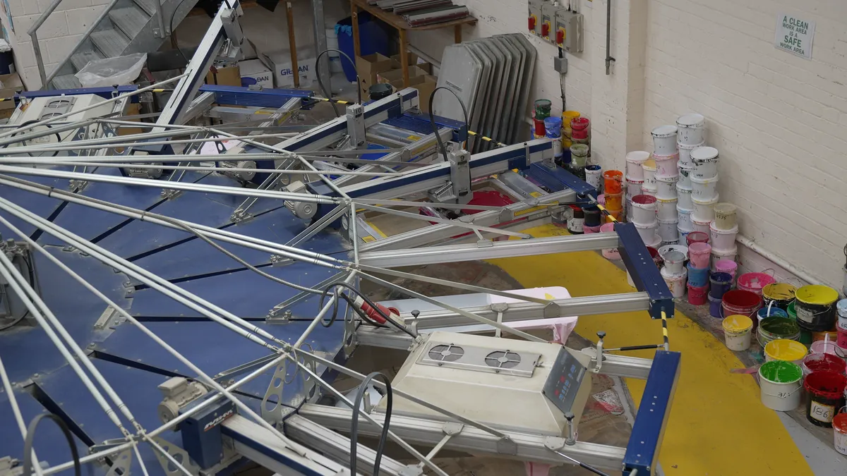 The arms of a carousel screen press