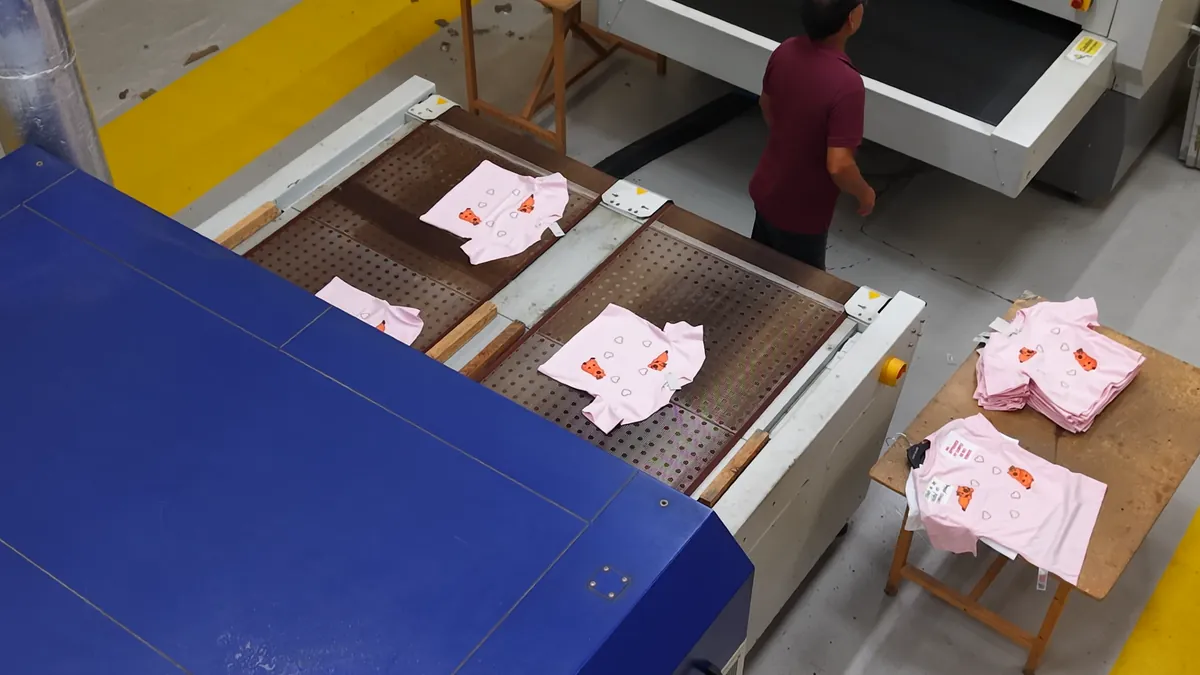 Printed garments coming off the conveyor dryer